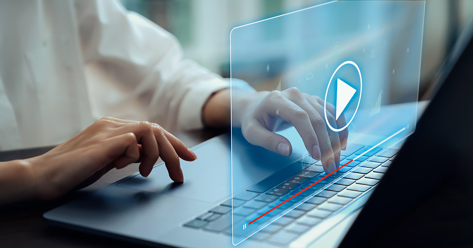 image of a woman pressing play on a laptop